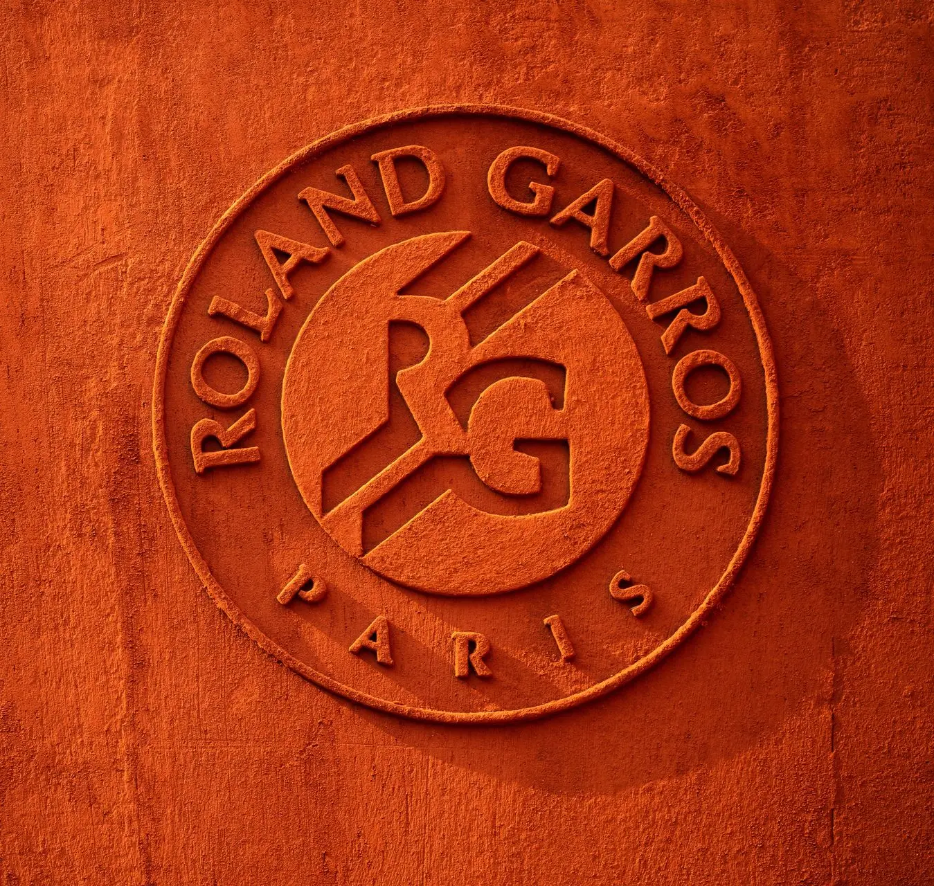 The official emblem of the Roland Garros tournament. Roland Garros logo on a clay court surface.