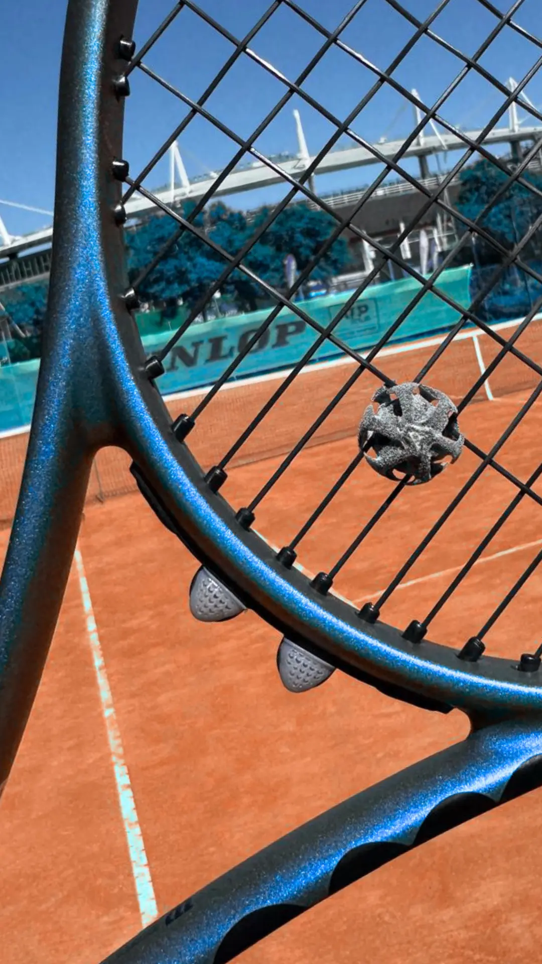 Raqueta tenis con antivibrador detalle Detalle de cuerdas de raqueta de tenis con antivibrador instalado