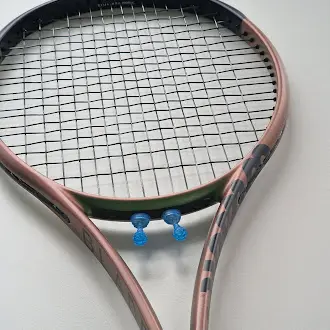 Tennis racquet detail showing vibration control accessories