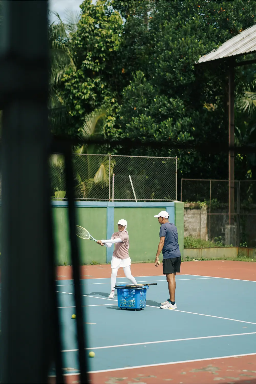 Test du comportement de la raquette sur le court Joueur de tennis testant le comportement de la raquette pendant une séance d’entraînement sur un court en dur