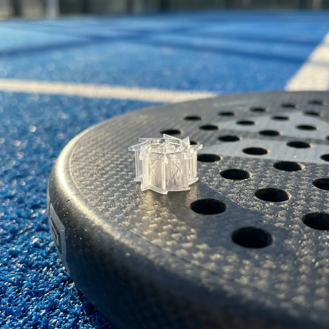 Close-up of vibration dampener on padel racket surface showing precision and material detail