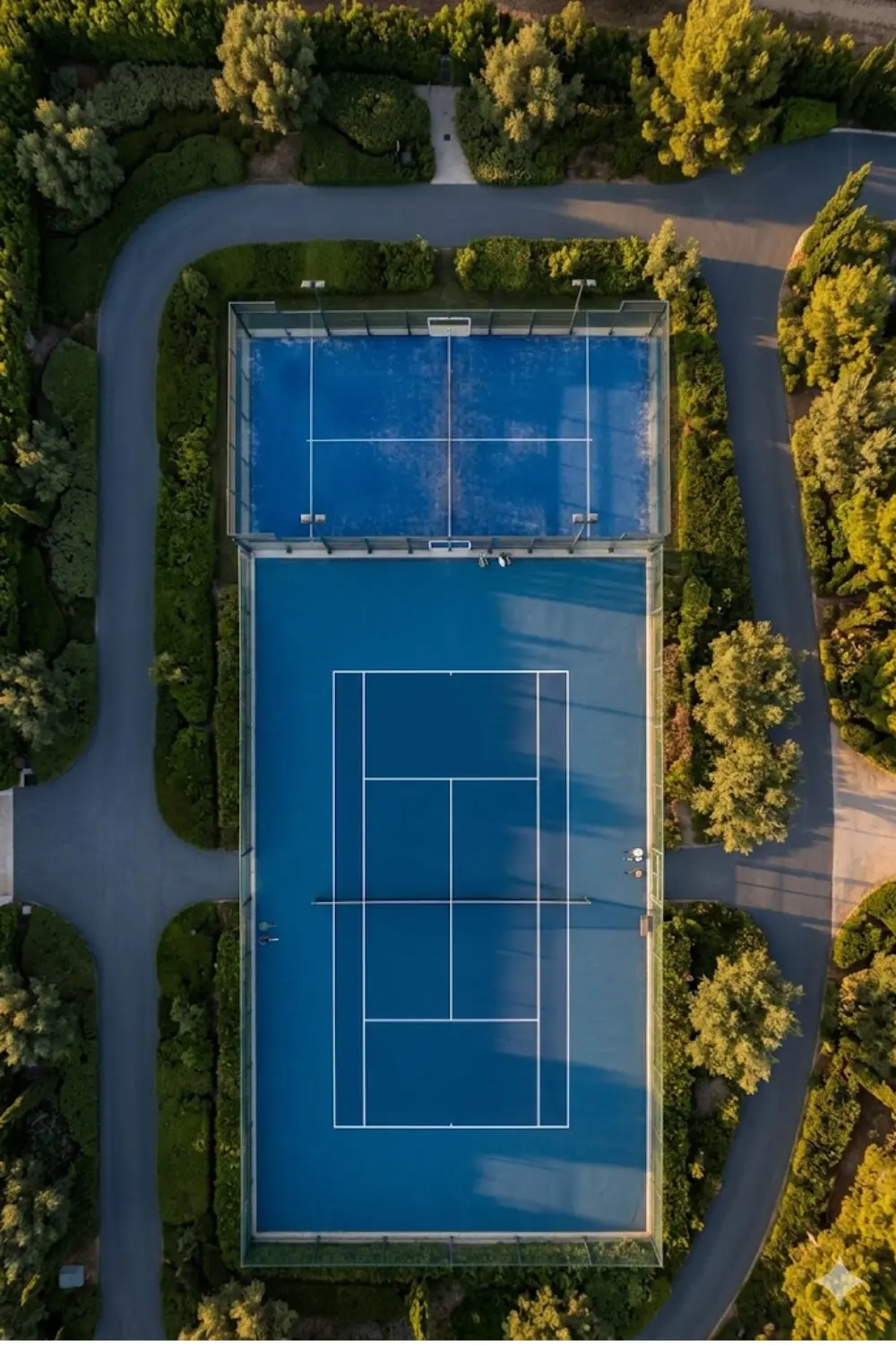 Mejor hora para jugar tenis y pádel en verano Pistas de tenis y pádel vistas desde arriba al atardecer, mostrando por qué los horarios más frescos son mejores en verano.